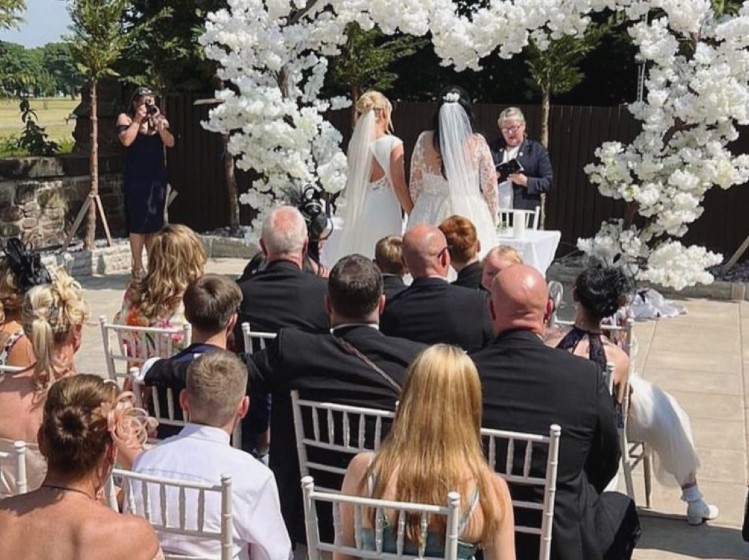 Ceremony outside under heart of flowers